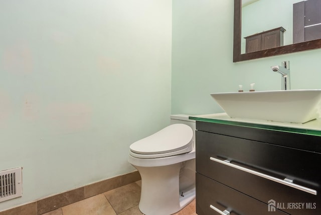 bathroom with tile patterned flooring, visible vents, baseboards, toilet, and vanity