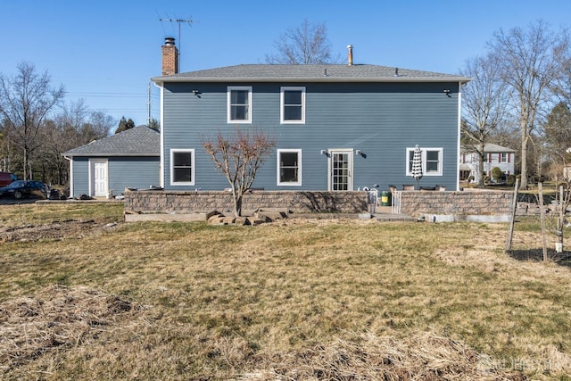 rear view of property featuring a lawn and a chimney