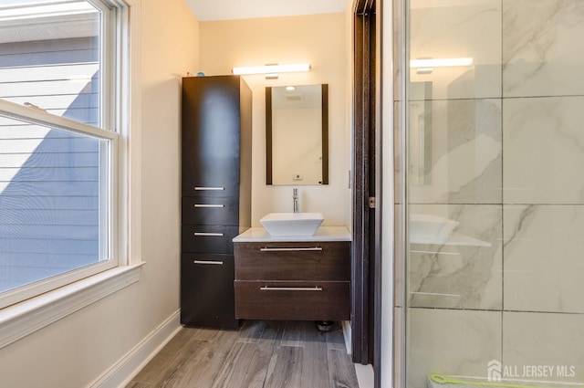 full bathroom with a wealth of natural light, a shower stall, wood finished floors, and vanity