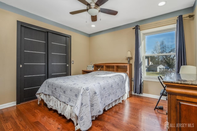 bedroom with recessed lighting, multiple windows, baseboards, and wood finished floors