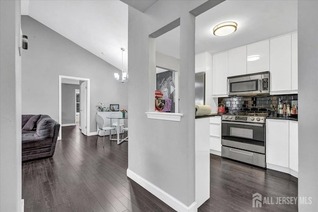 kitchen with dark countertops, dark wood-style floors, white cabinetry, and stainless steel appliances