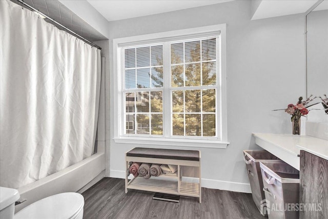 full bathroom featuring toilet, vanity, shower / bathtub combination with curtain, and hardwood / wood-style flooring