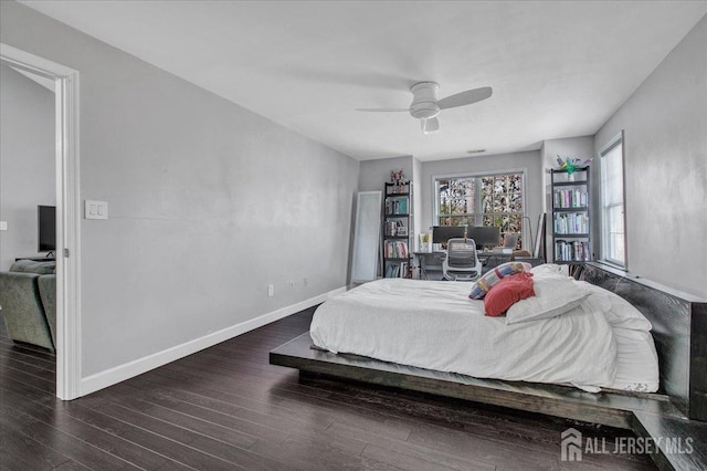 bedroom featuring ceiling fan, baseboards, and wood finished floors