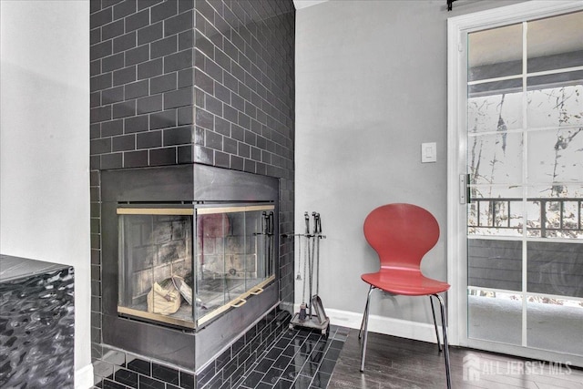 details featuring wood finished floors, baseboards, and a glass covered fireplace