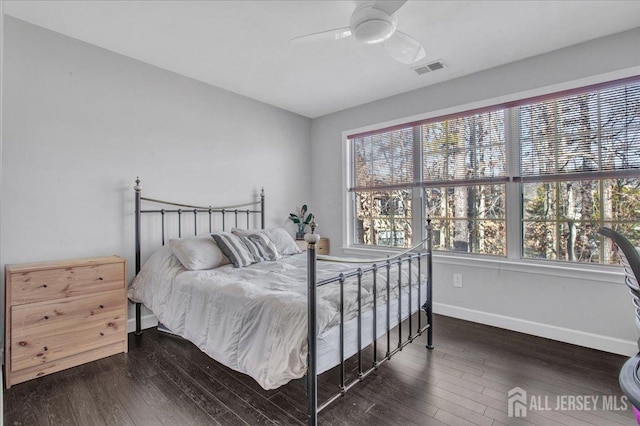 bedroom featuring a ceiling fan, hardwood / wood-style flooring, visible vents, and baseboards