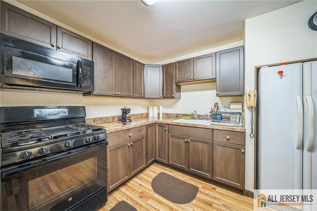 116 Whitman St, Carteret, NJ 07008 - kitchen with black appliances, light wood-type flooring, and light countertops