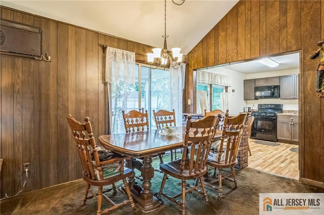 116 Whitman St, Carteret, NJ 07008 - dining space with wood walls, vaulted ceiling, a chandelier, carpet flooring, and a wall unit AC