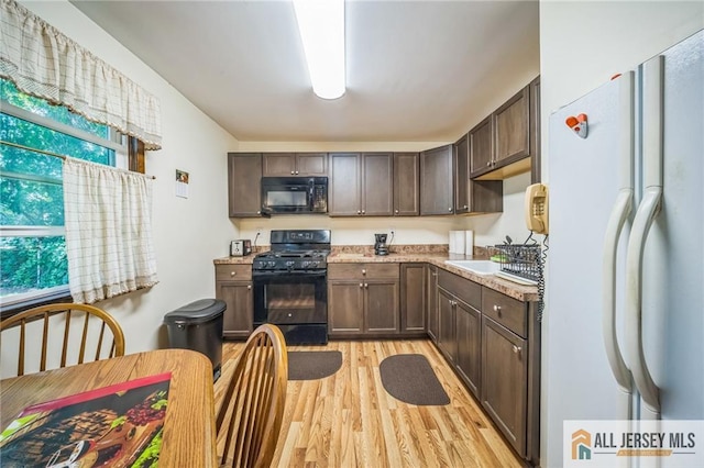 116 Whitman St, Carteret, NJ 07008 - kitchen featuring black appliances, light wood-style floors, and dark brown cabinets