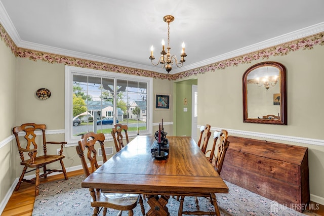 dining room featuring crown molding, a chandelier, and light wood-type flooring