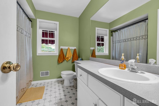 bathroom with vanity, curtained shower, and toilet