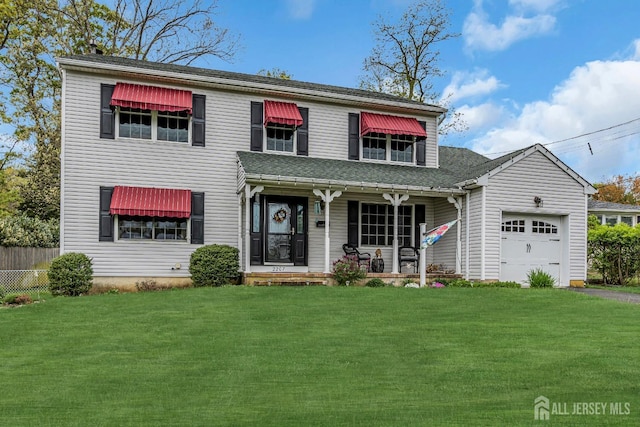 view of front of property with a garage, covered porch, and a front yard