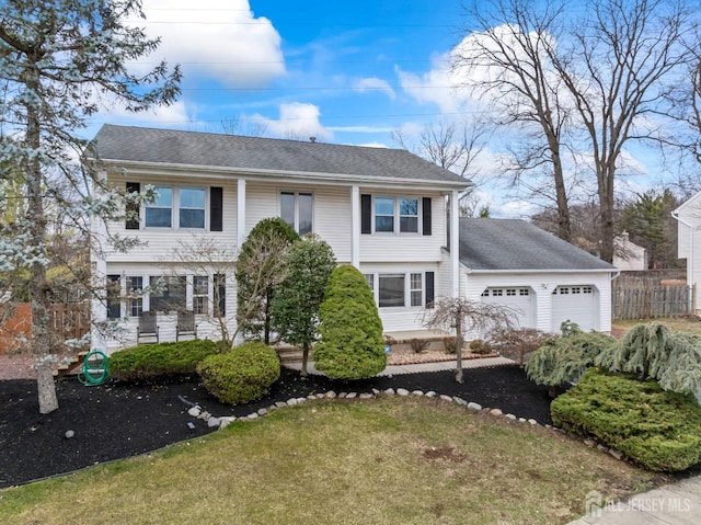 view of front of home with an attached garage, a shingled roof, and fence