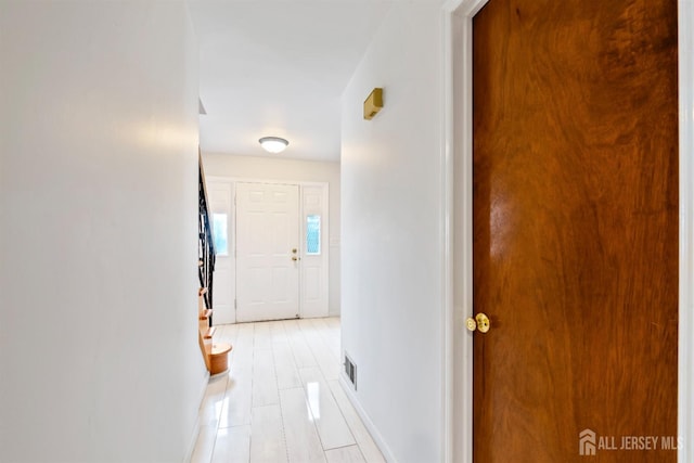 hall featuring visible vents and baseboards