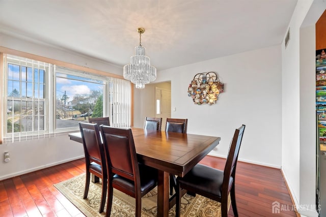 dining area with visible vents, baseboards, an inviting chandelier, and hardwood / wood-style flooring