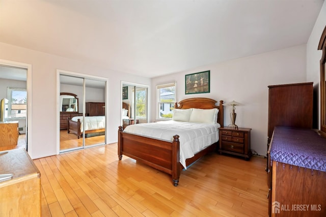 bedroom with two closets and light wood finished floors