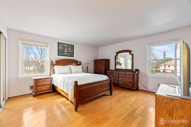 bedroom with light wood-style flooring and multiple windows