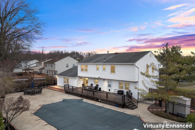 rear view of property featuring fence, outdoor dining area, an outdoor structure, a deck, and a patio