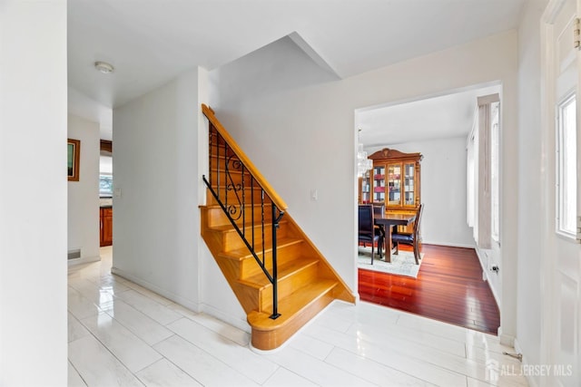 stairway with wood finished floors and baseboards