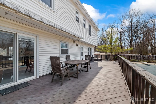 deck with outdoor dining area and fence