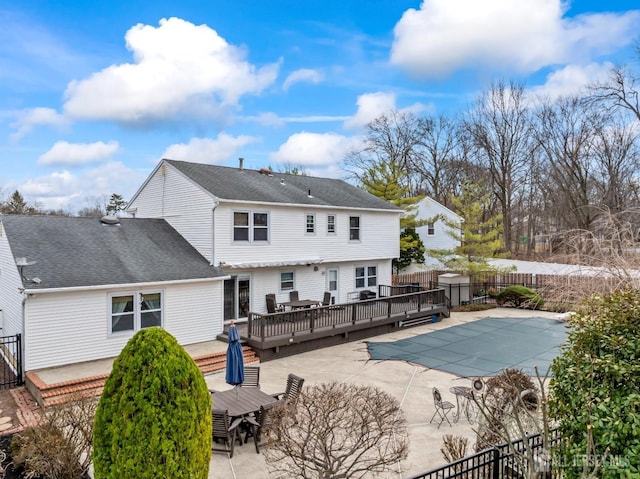 back of house featuring a fenced in pool, fence, outdoor dining area, a deck, and a patio area