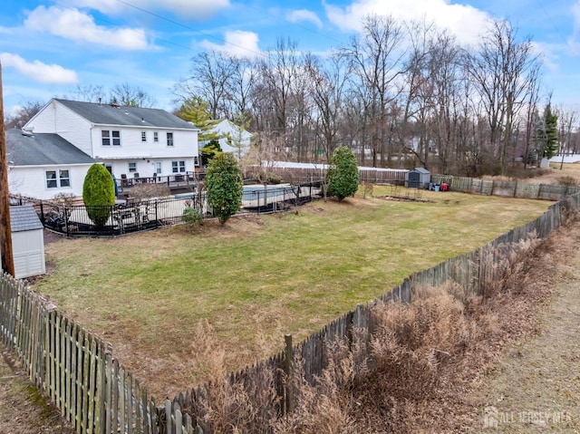 view of yard with an outbuilding, a storage shed, and a fenced backyard