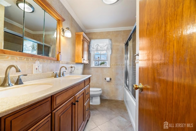 full bathroom with tile walls, ornamental molding, and a sink