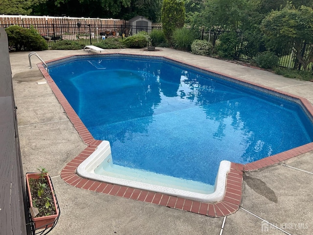 view of swimming pool with a diving board, a fenced in pool, and a fenced backyard