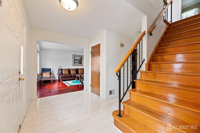 stairway featuring visible vents and wood finished floors