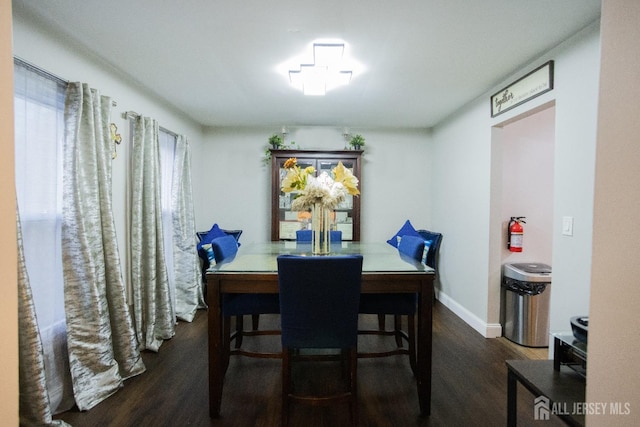 dining area with baseboards and wood finished floors