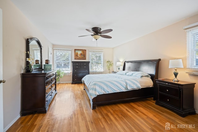 bedroom with a ceiling fan, light wood-type flooring, and baseboards