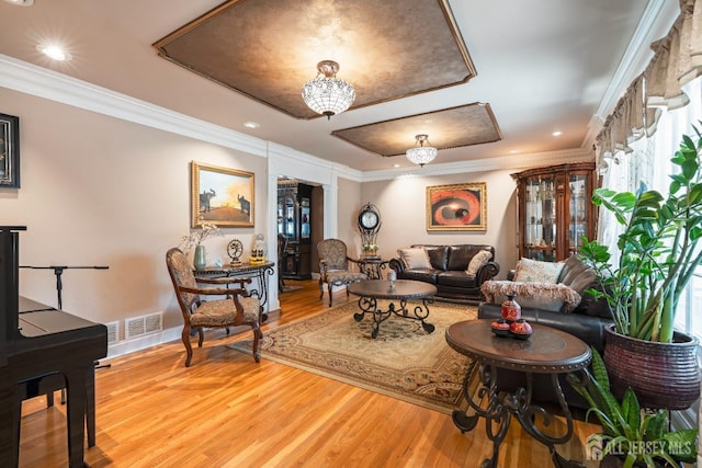 interior space featuring visible vents, crown molding, a notable chandelier, and wood finished floors