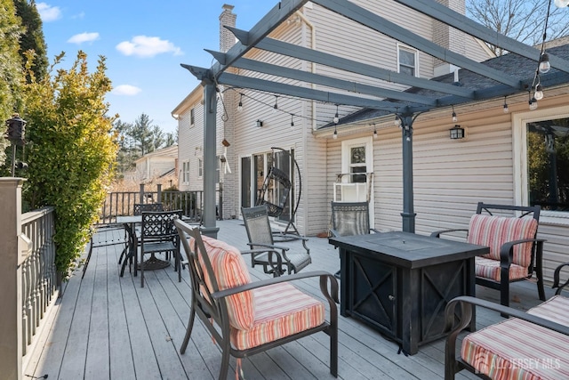 wooden terrace with a fire pit, outdoor dining area, and a pergola