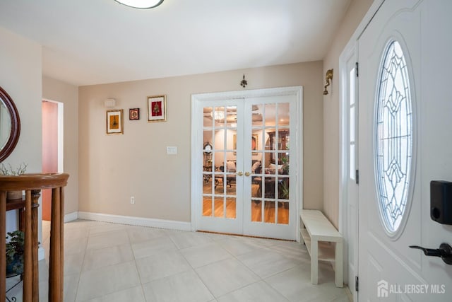 entrance foyer featuring french doors, light tile patterned flooring, and baseboards