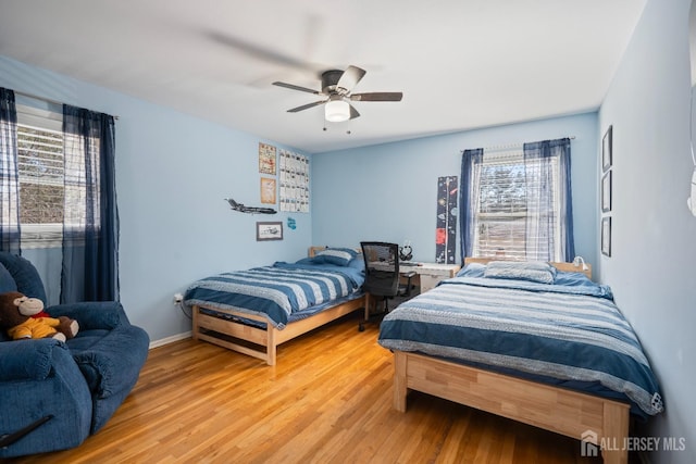 bedroom featuring wood finished floors, a ceiling fan, and baseboards