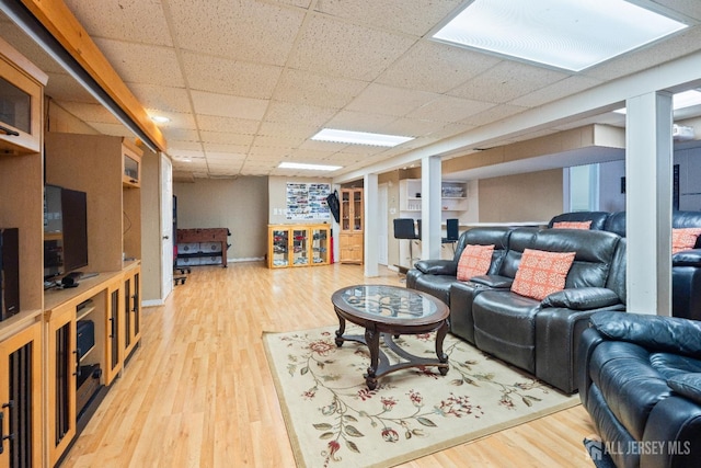 living area featuring a paneled ceiling and wood finished floors