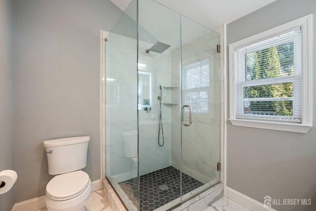 full bath featuring marble finish floor, a stall shower, toilet, and baseboards