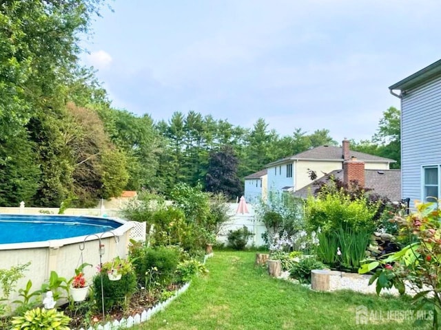 pool with fence and a yard