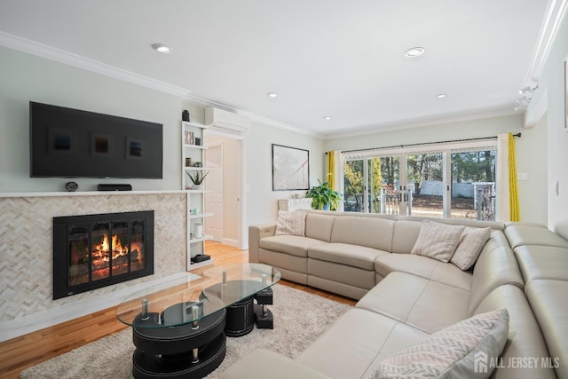 living area featuring ornamental molding, a tile fireplace, an AC wall unit, and wood finished floors