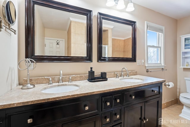 full bath featuring double vanity, a sink, toilet, and tile patterned floors