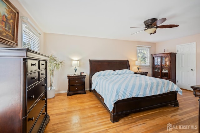 bedroom featuring ceiling fan, light wood-style flooring, and baseboards