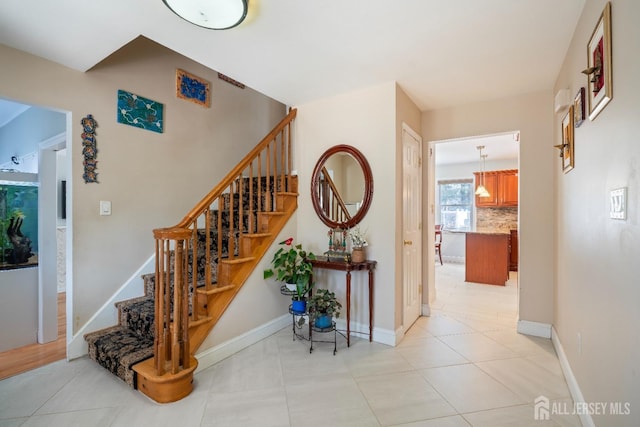 stairway featuring tile patterned flooring and baseboards