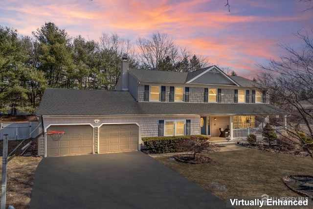 view of front of house with roof with shingles, a chimney, covered porch, an attached garage, and driveway