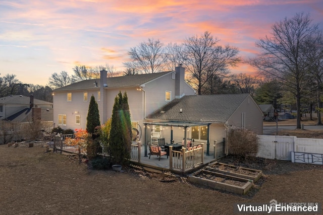 back of house featuring fence, a garden, a pergola, a chimney, and a patio area