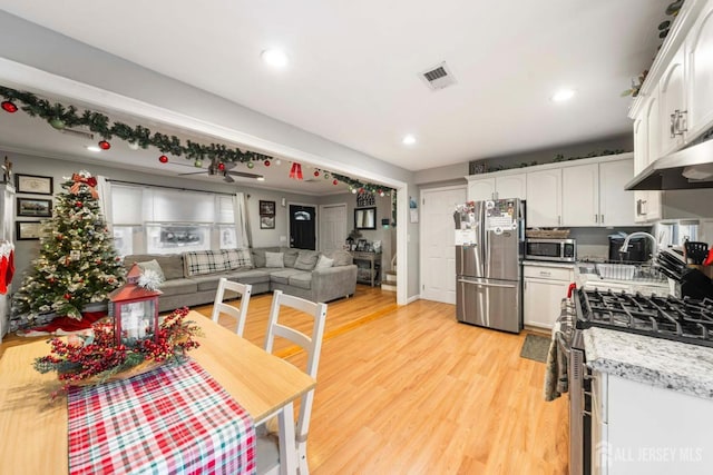 kitchen featuring appliances with stainless steel finishes, white cabinets, and light hardwood / wood-style floors