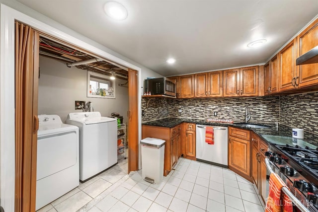 kitchen with sink, light tile patterned floors, stainless steel appliances, independent washer and dryer, and tasteful backsplash