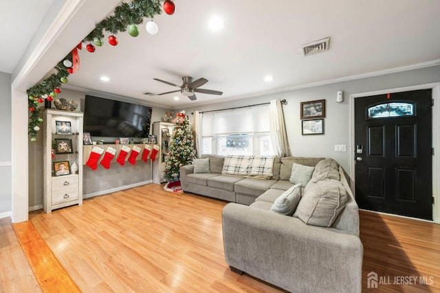 living room featuring crown molding, hardwood / wood-style flooring, and ceiling fan