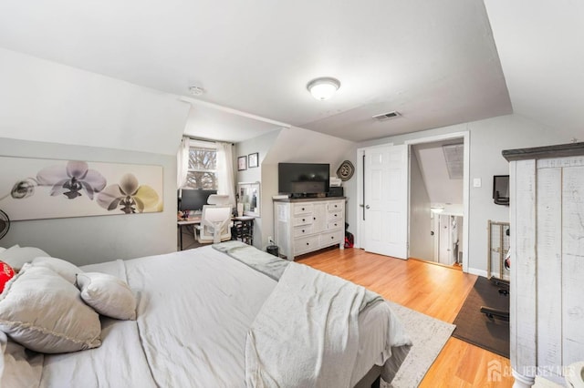 bedroom featuring vaulted ceiling and light hardwood / wood-style floors