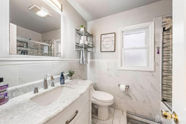 bathroom with walk in shower, vanity, toilet, and tile walls