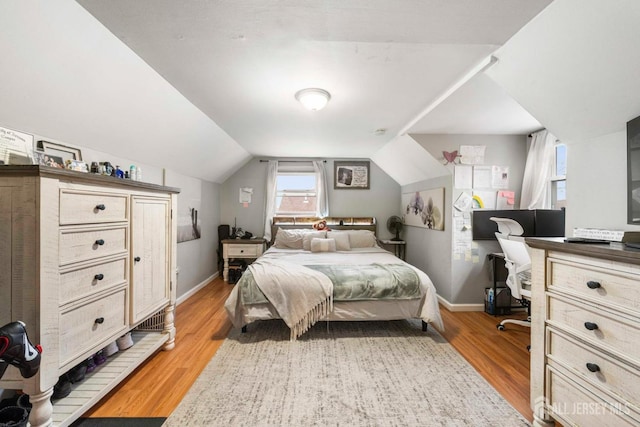 bedroom with lofted ceiling and light hardwood / wood-style floors