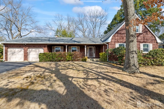 view of front facade featuring an attached garage and aphalt driveway